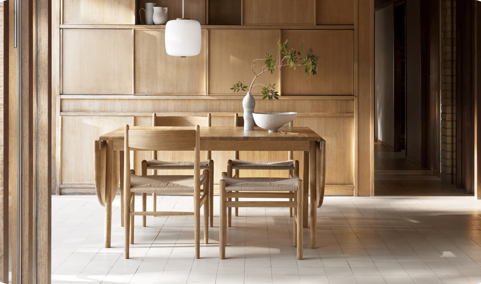 Wood dining table and chairs in a paneled room