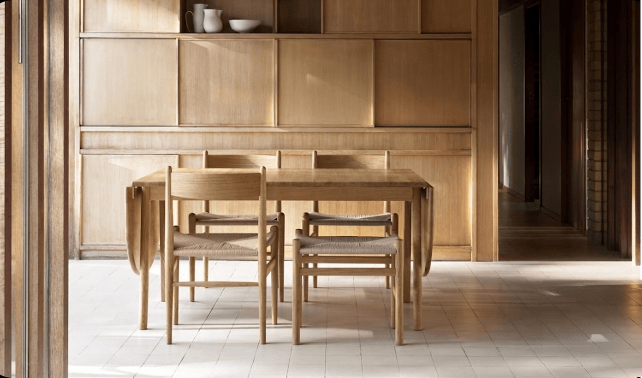 Wood dining table and chairs in a paneled room